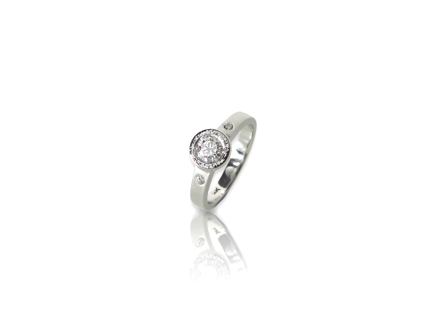 ZEALmetal classic planish bezel diamond ring with accent diamond side stones.