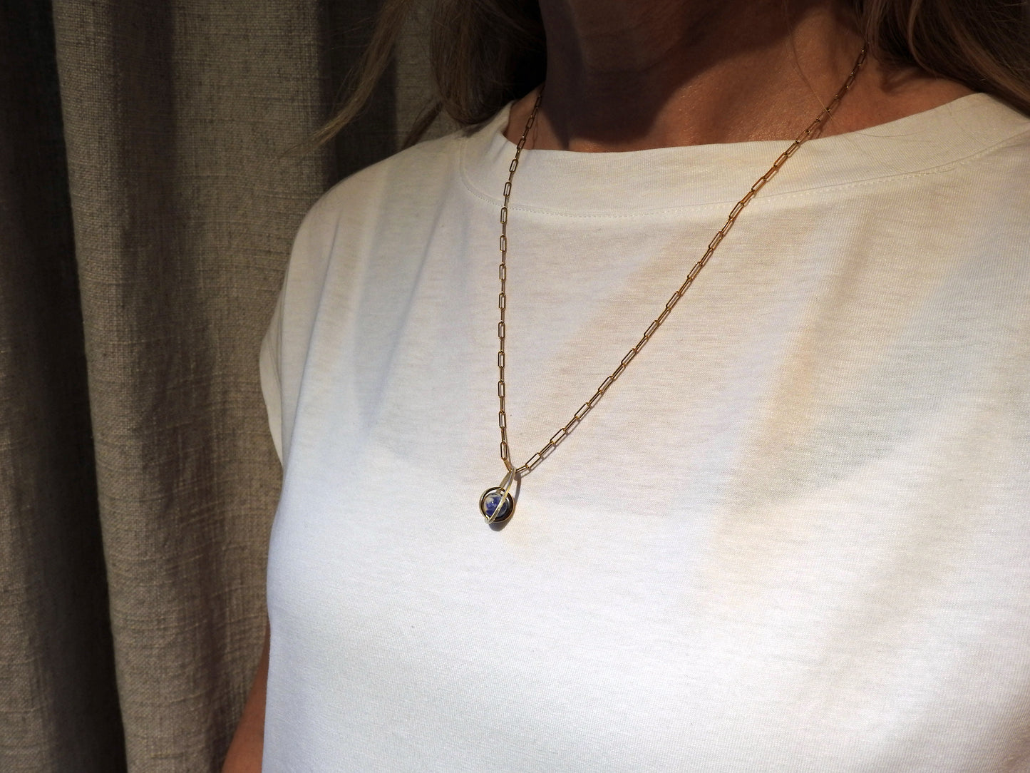 Worldly perspective: new pendant added to the Astral collection . 14 kt yellow gold band within sterling silver wire drop shape holding a free floating worldly looking sodalite undrilled sphere bead.   on 14kty 18" cable chain, by ZEALmetal, Nicole Horlor, in Kingston, ON, Canada