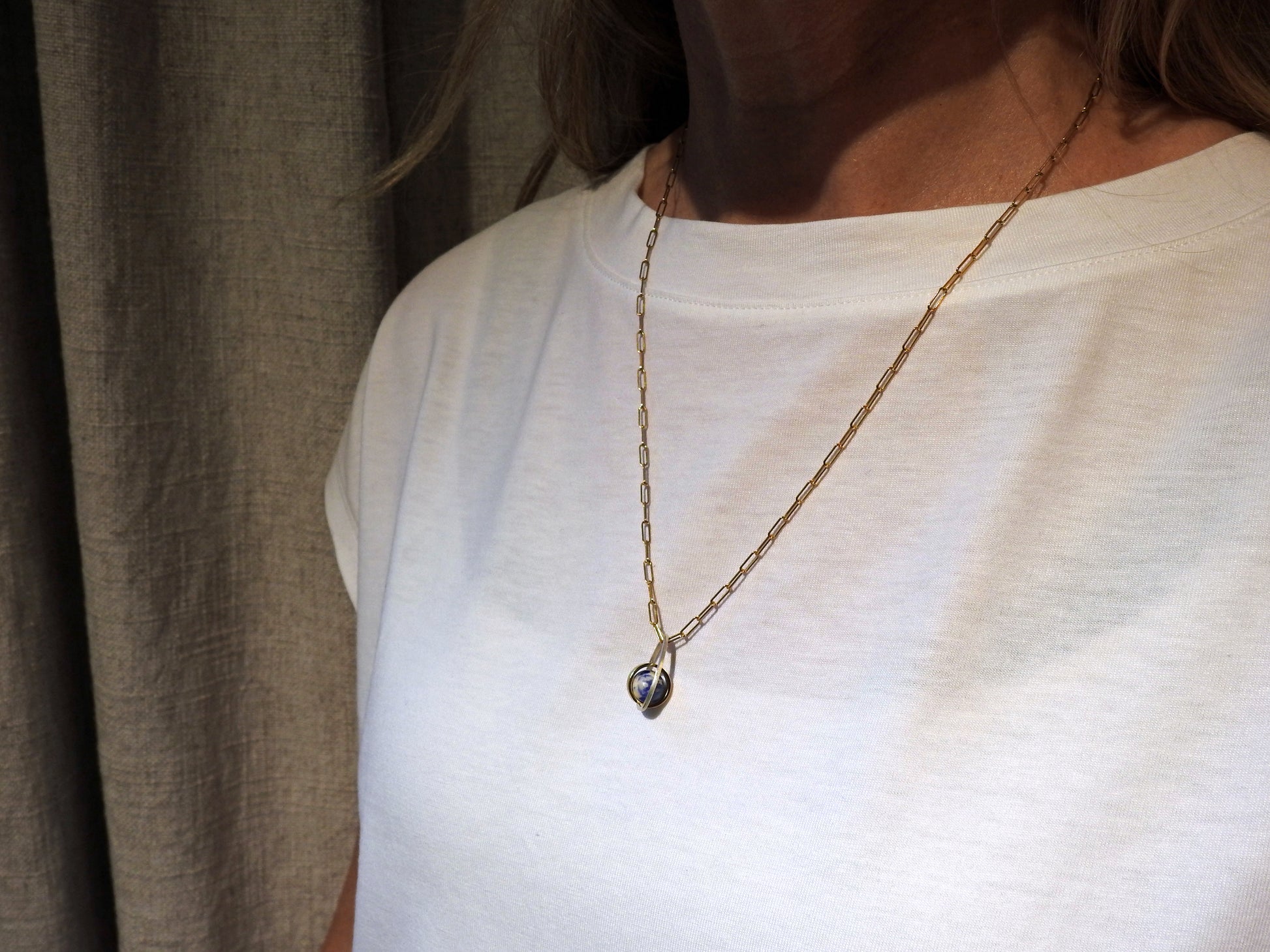 Worldly perspective: new pendant added to the Astral collection . 14 kt yellow gold band within sterling silver wire drop shape holding a free floating worldly looking sodalite undrilled sphere bead.   on 14kty 18" cable chain, by ZEALmetal, Nicole Horlor, in Kingston, ON, Canada
