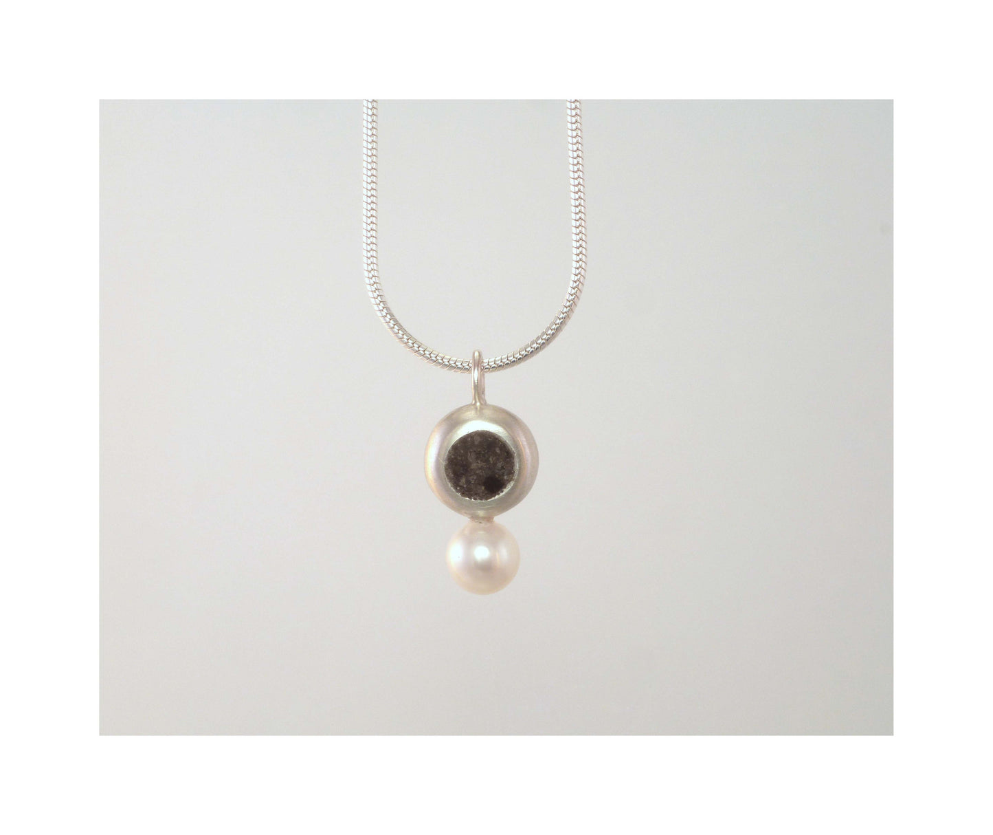 Circle with limestone inlay and pearl