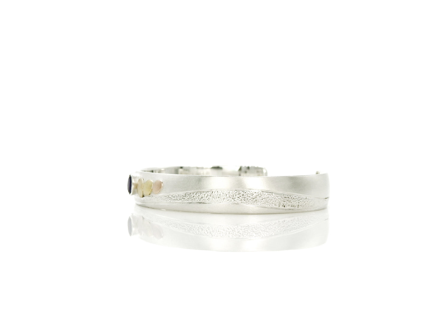 sterling silver with 14kt yellow and red gold pebbles and 18kt yellow gold pebble, with 6x4mm oval facetted amethyst set in sterling silver bezel, hand carving and planish detailing. bracelet by ZEALmetal, Nicole Horlor, in Kingston, ON Canada