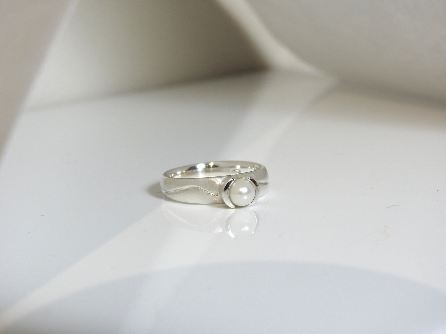 Flared bezel carved with pearl