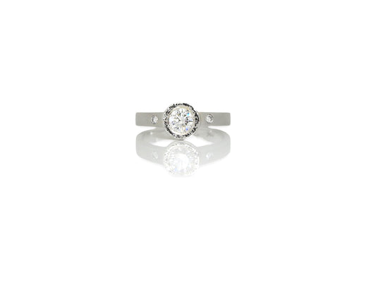 ZEALmetal classic planish bezel diamond ring with accent diamond side stones.