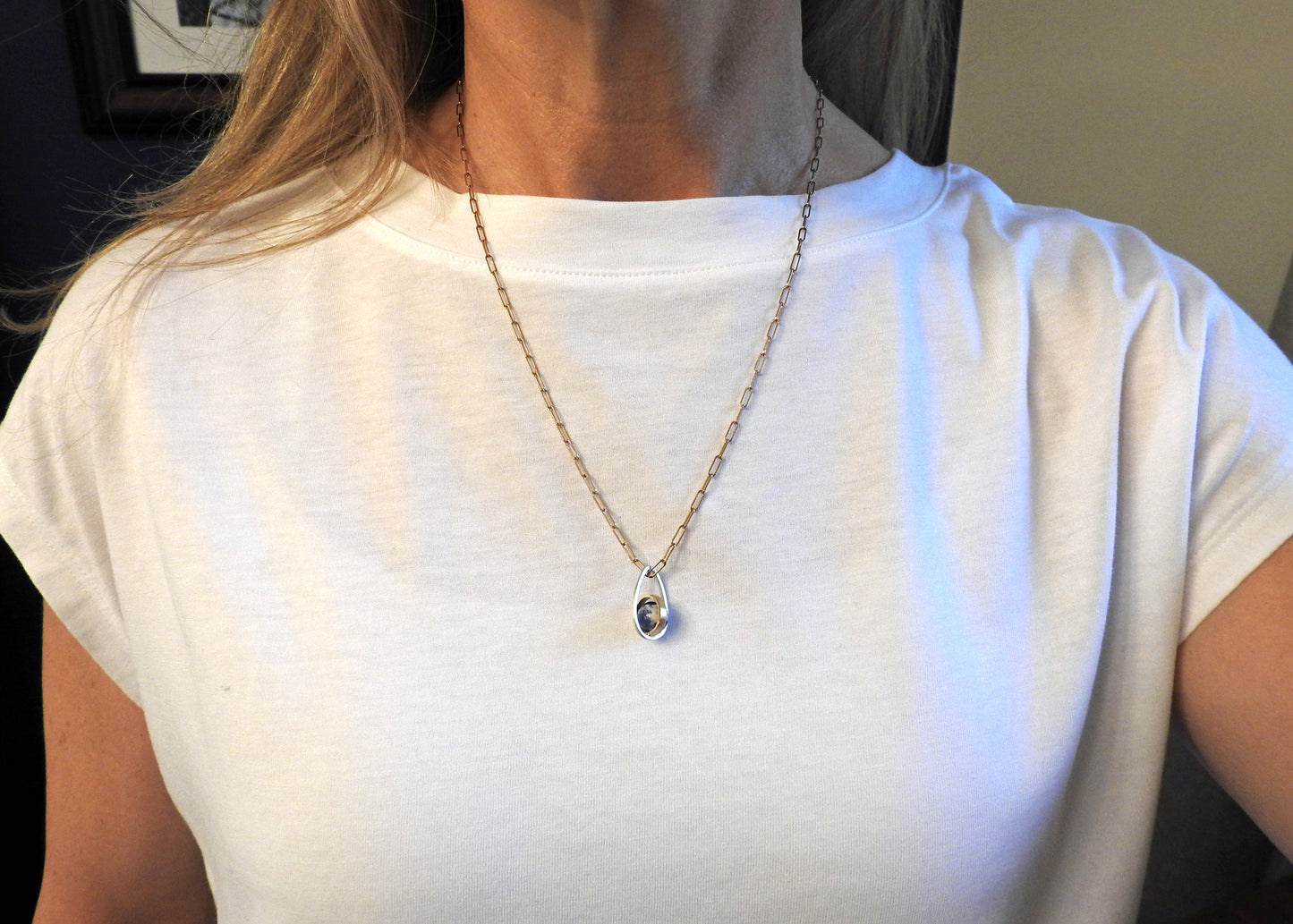 Worldly perspective: new pendant added to the Astral collection . 14 kt yellow gold band within sterling silver wire drop shape holding a free floating worldly looking sodalite undrilled sphere bead.   on 14kty 18" cable chain, by ZEALmetal, Nicole Horlor, in Kingston, ON, Canada