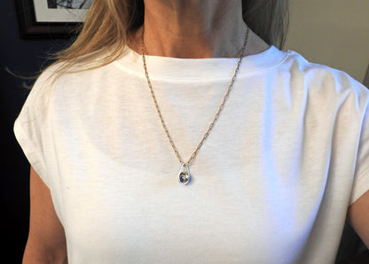 Worldly perspective: new pendant added to the Astral collection . 14 kt yellow gold band within sterling silver wire drop shape holding a free floating worldly looking sodalite undrilled sphere bead.   on sterling silver 18" cable chain, by ZEALmetal, Nicole Horlor, in Kingston, ON, Canada