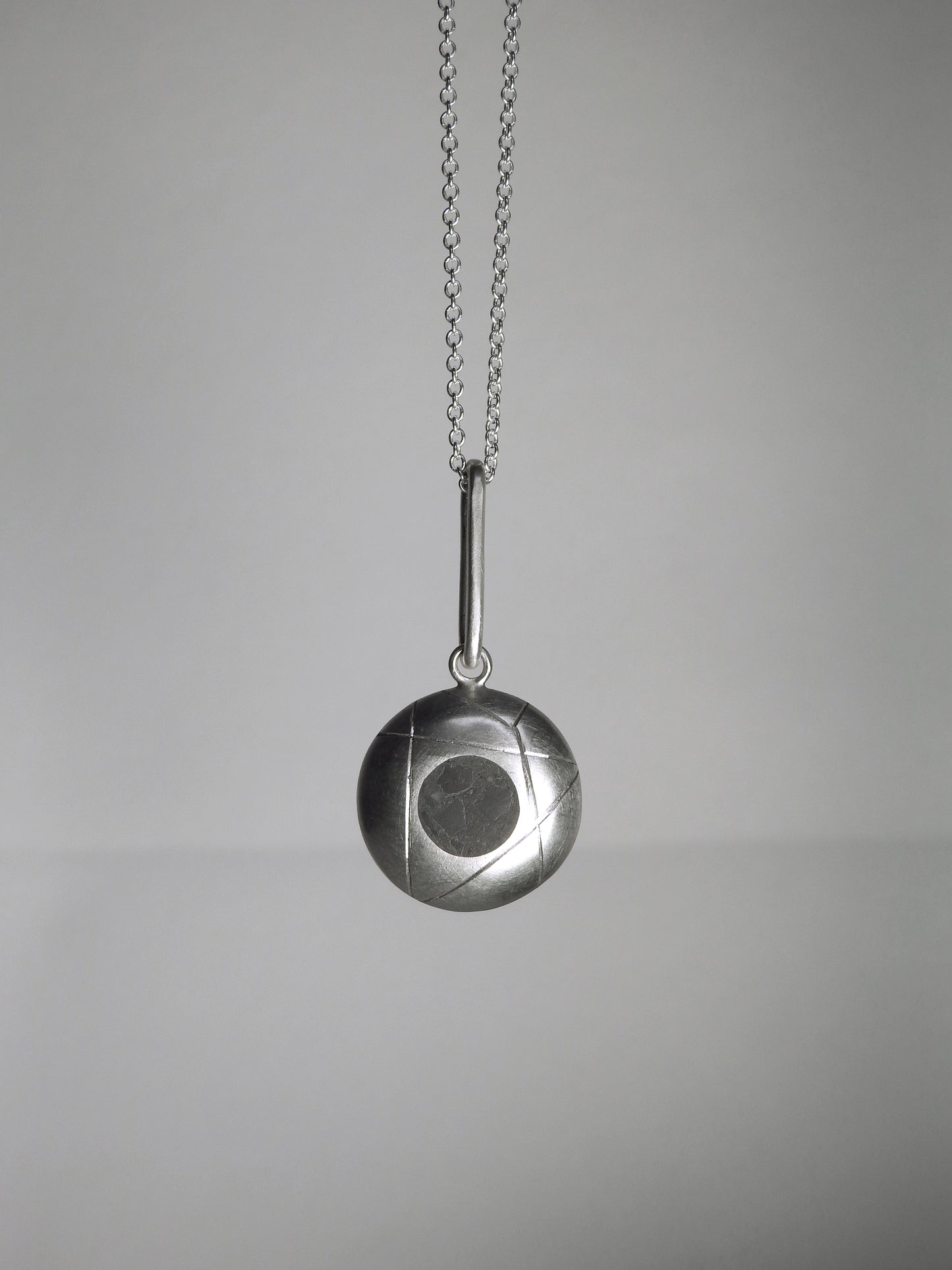 Pendulum style pendant, half dome with limestone inlay, with accent carved lines hanging on elongated bale, matte and high-polish accent finishes, on 18" rounded box link chain, by ZEALmetal, Nicole Horlor, in Kingston, ON, Canada