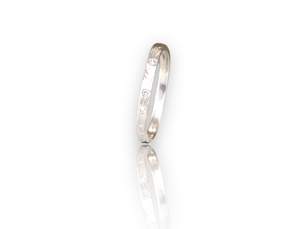 2.5mm band with hand carved vine pattern and hand stamped leafs scattered around band, with 3 x 1pter accent round brilliant cut diamonds for a little sparkle. Ring shown in image is a soft square shape but this ring can also be round, by ZEALmetal, Nicole Horlor, in Kingston, ON, Canada